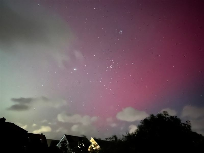 Polarlicht am Nachthimmel über den Dächern